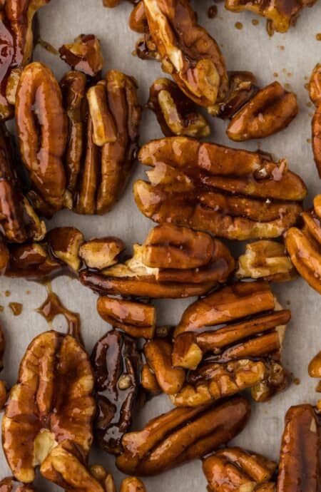 Closeup shot of glazed candied pecans on parchment paper