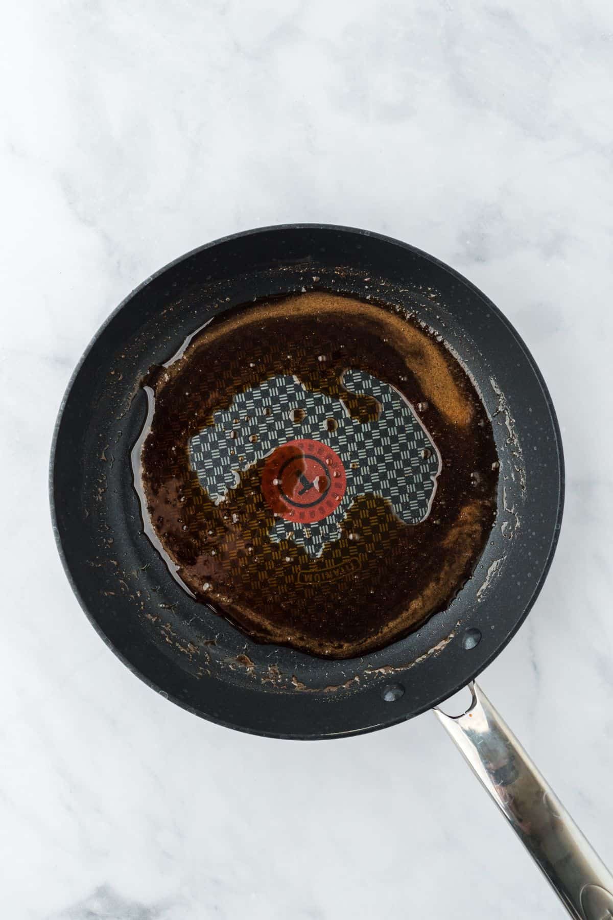 The contents in the frying pan after melting, creating a caramel-like liquid