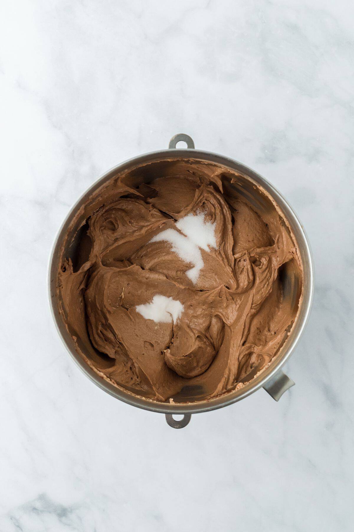 Chocolate pound cake batter in a mixing bowl with salt and baking soda sprinkled on top