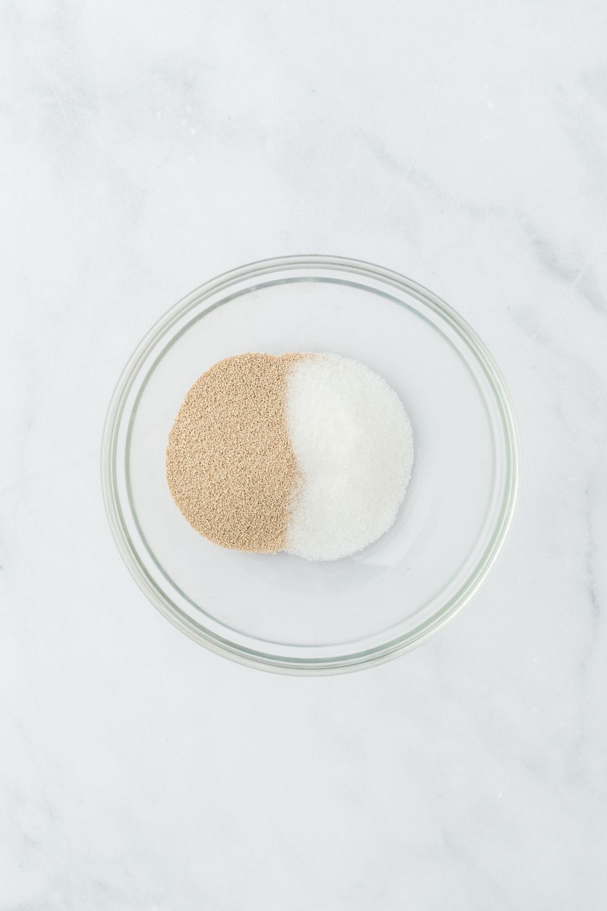 A small glass bowl with dry yeast and granulated sugar