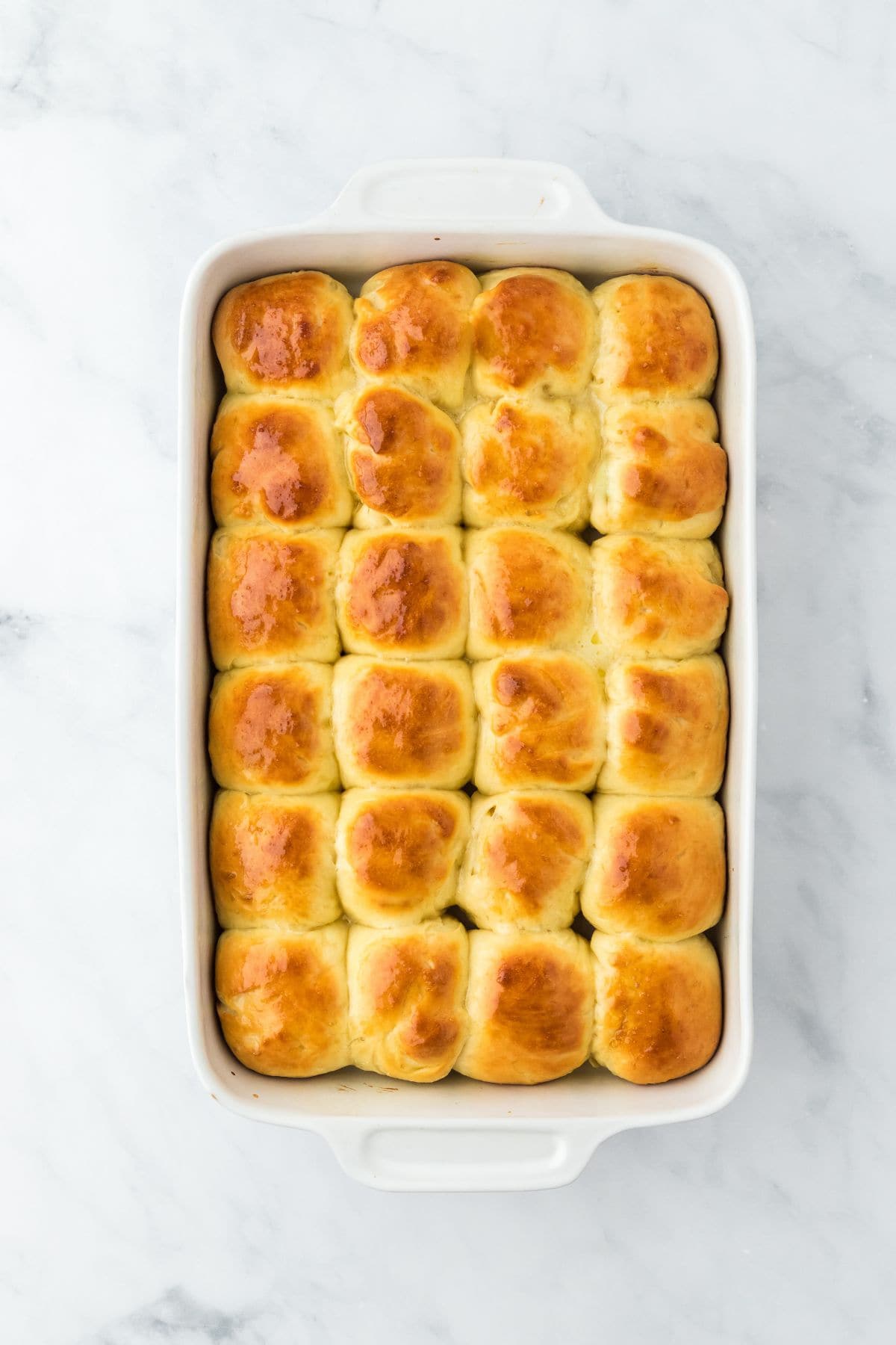 Golden-brown, freshly baked yeast rolls in the baking dish