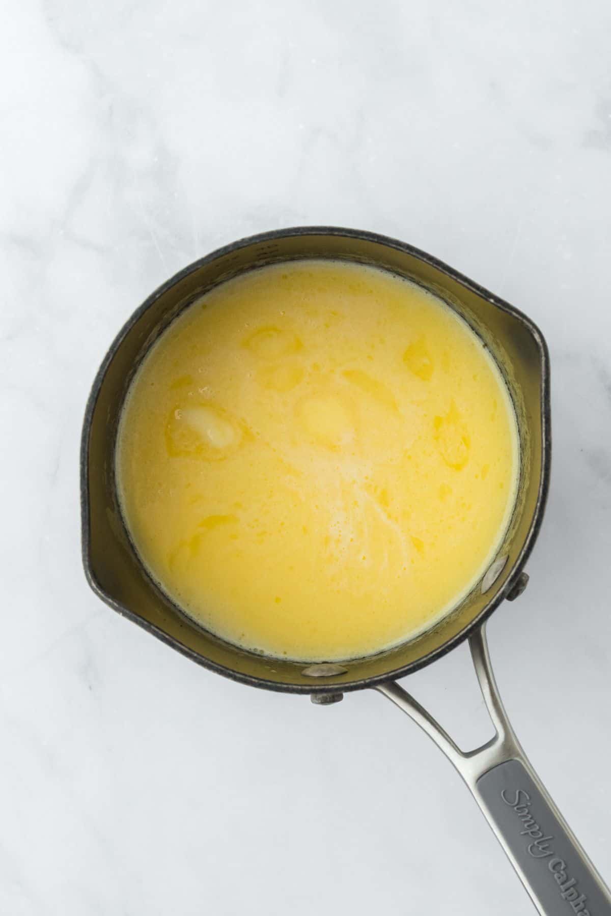 A small saucepan filled with melted butter and milk