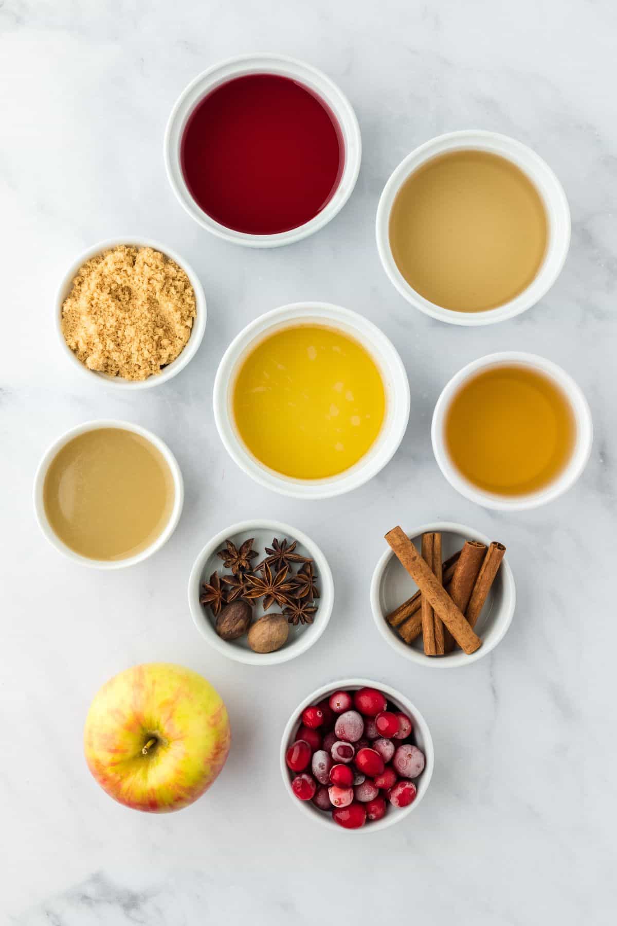 Overhead shot of ingredients to make thanksgiving punch on a marble surface before mixing