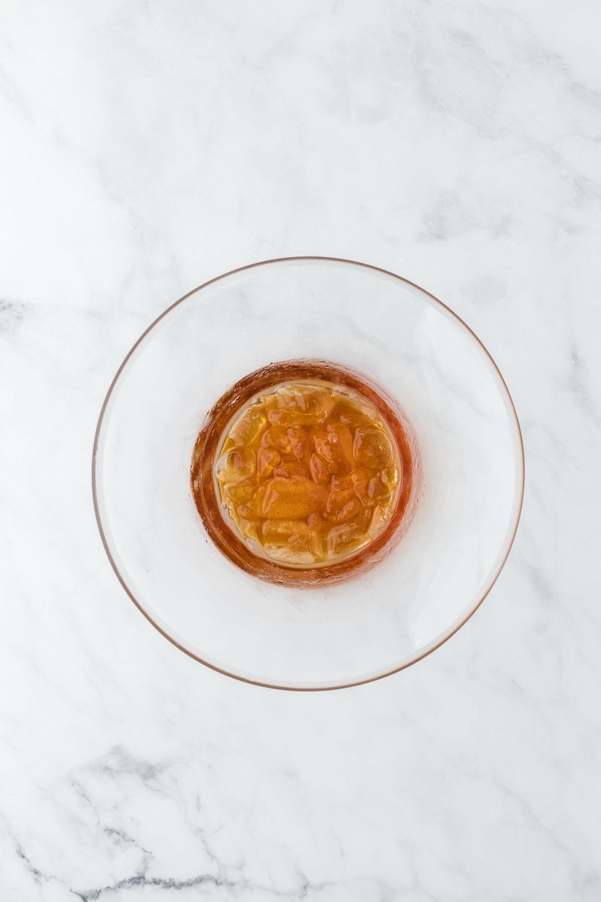 Overhead shot of a bowl filled with syrup and ice cubes