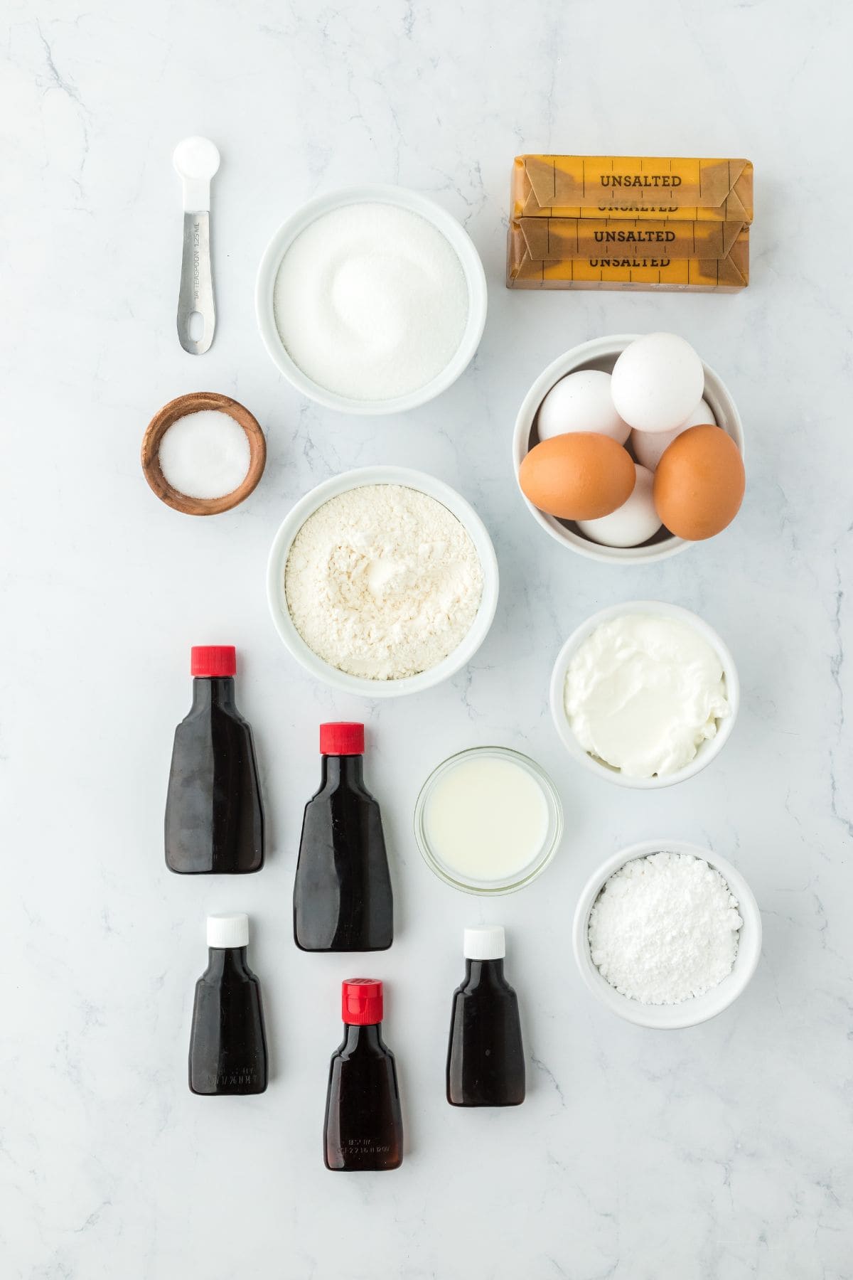 Overhead shot of ingredients for making five flavor pound cake on a white surface before mixing