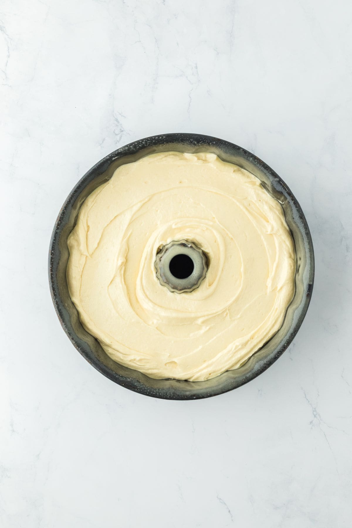 A bundt pan filled with the prepared cake batter, ready to be baked