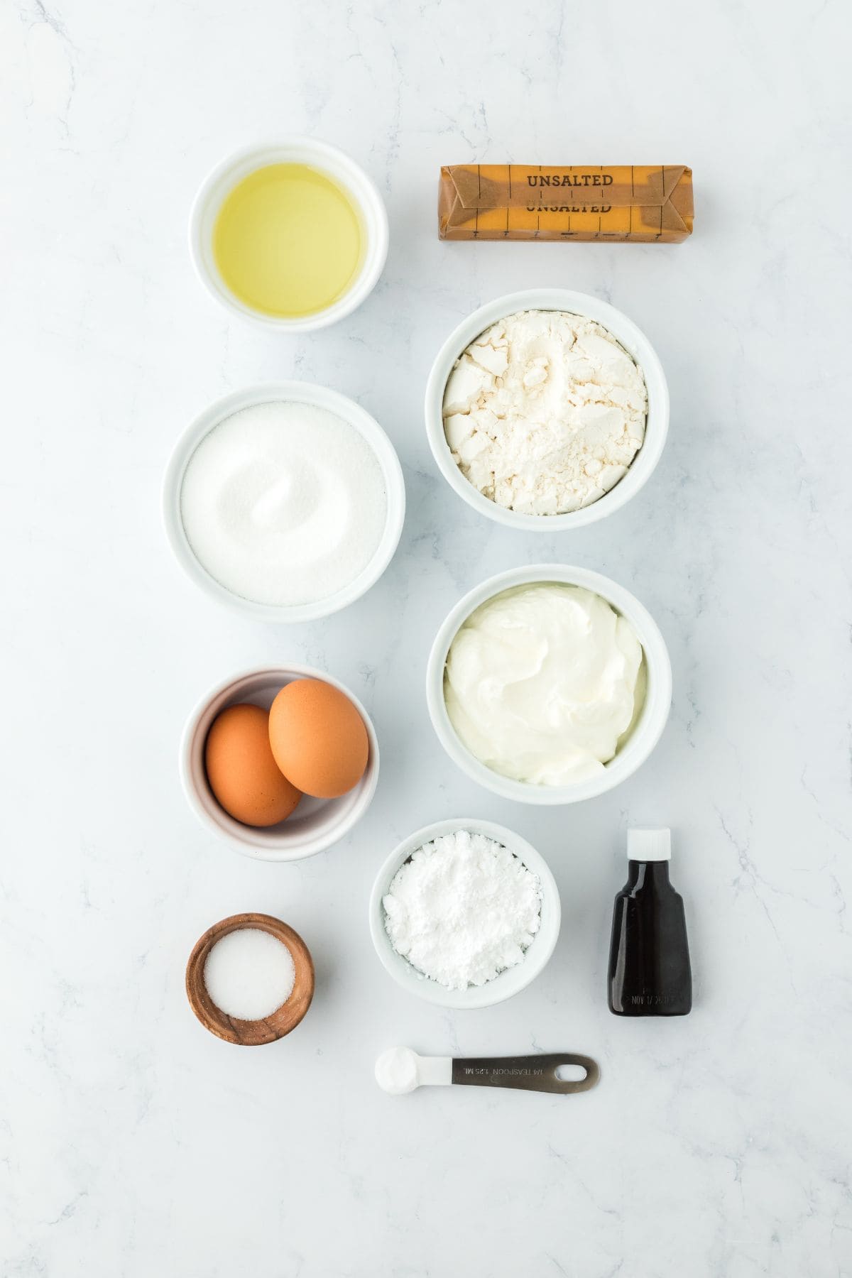 Overheat shot of ingredients for making pound cake beignets on a white surface before mixing