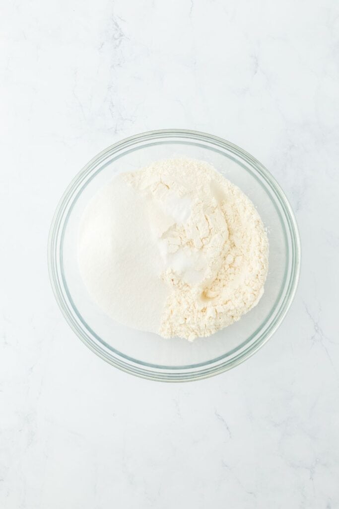 A glass mixing bowl with dry ingredients