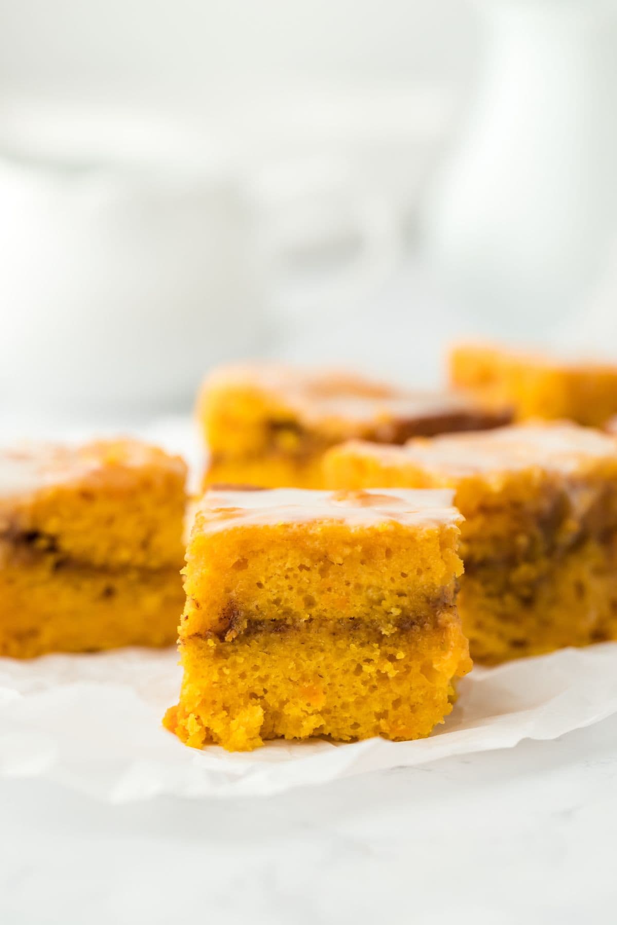 Multiple slices of Sweet Potato Honey Bun Cake arranged on a white surface