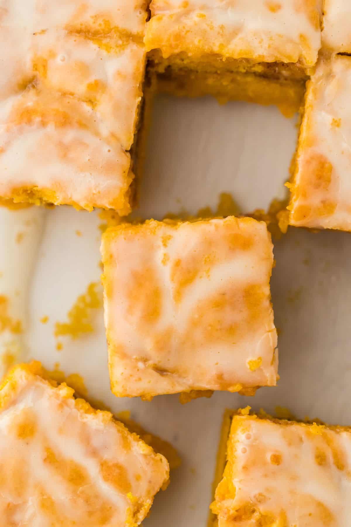 Closeup of square pieces of Sweet Potato Honey Bun Cake topped with a light glaze