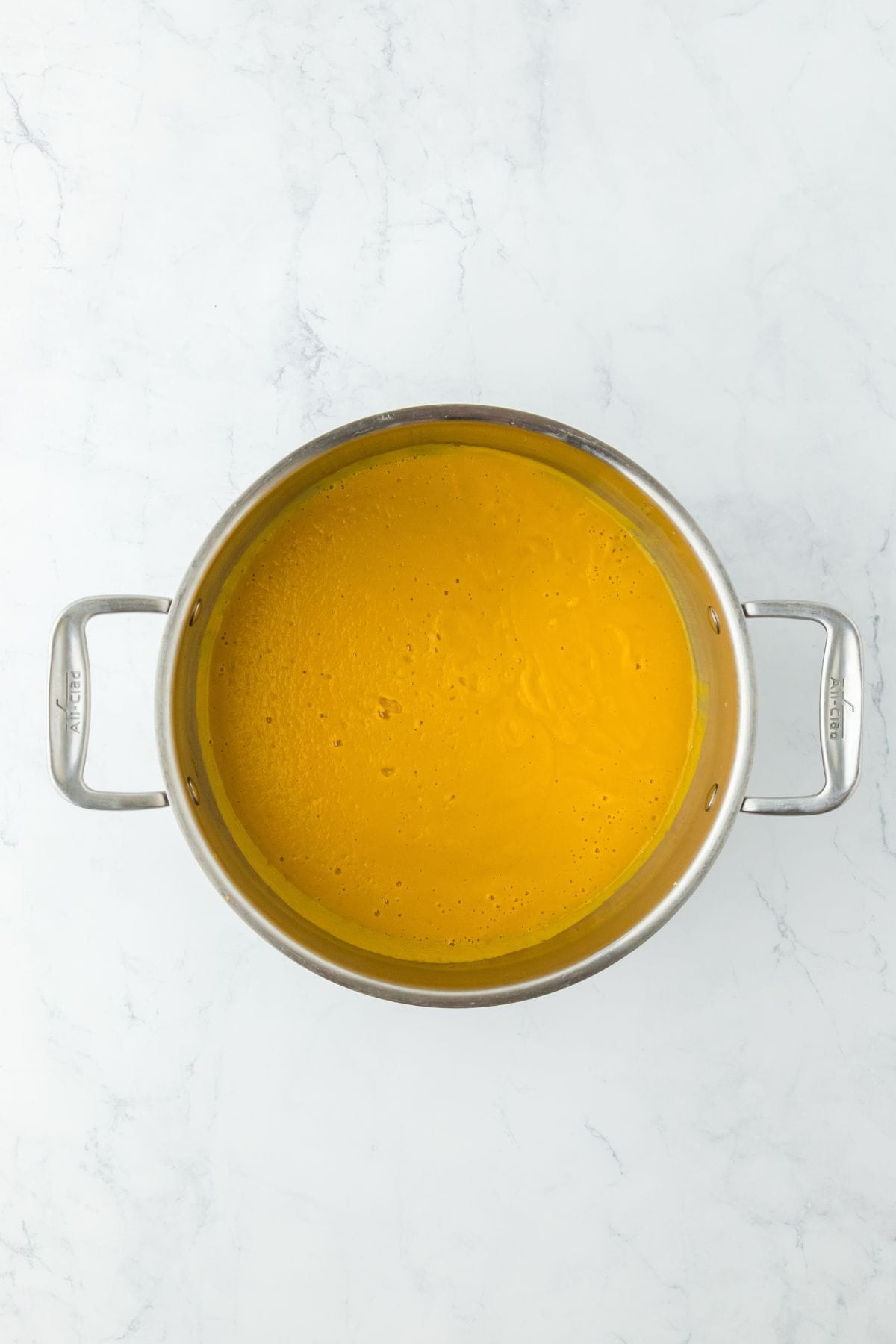 The soup ingredients fully blended into a smooth, creamy orange puree in the pot