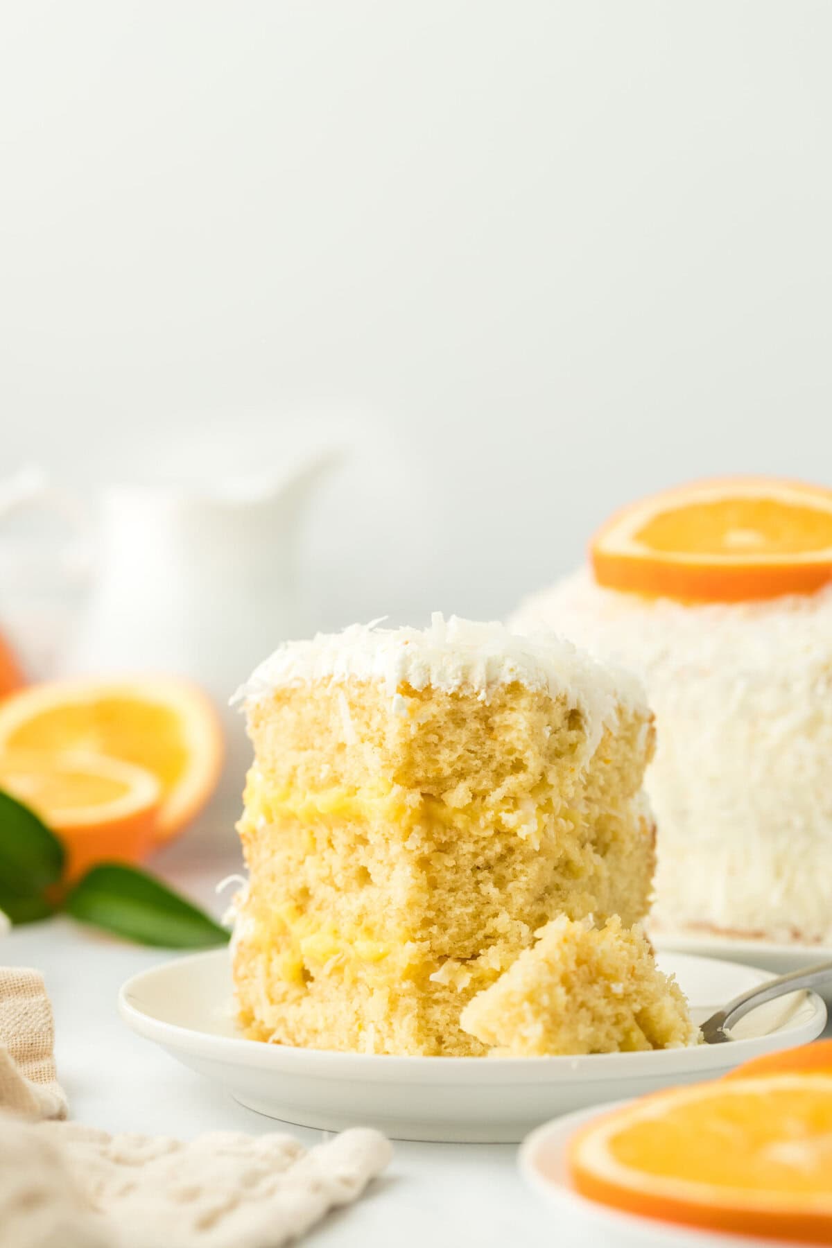 A slice of coconut orange cake with a fork in it