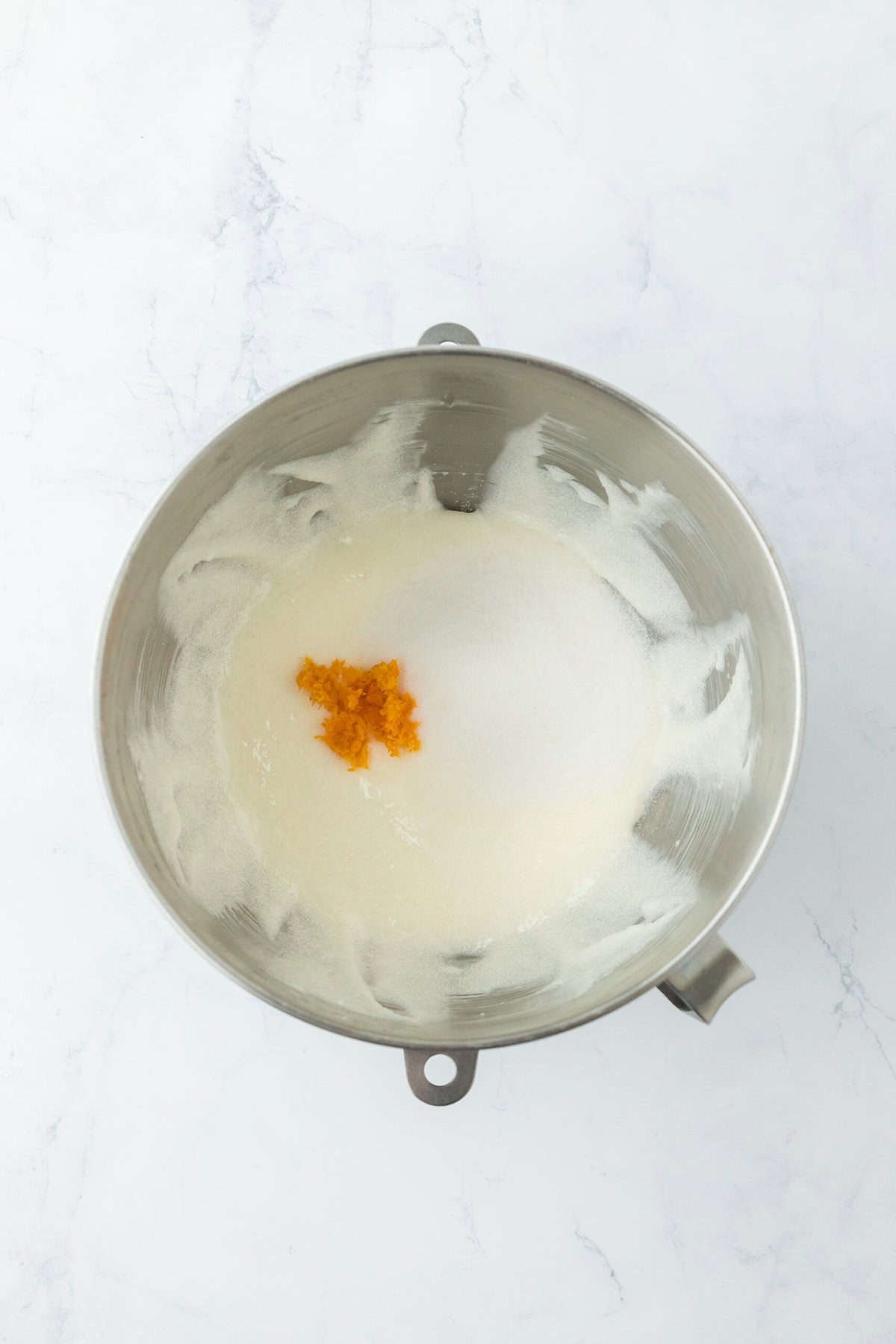 Orange zest added to creamed butter and sugar in a stand mixer bowl