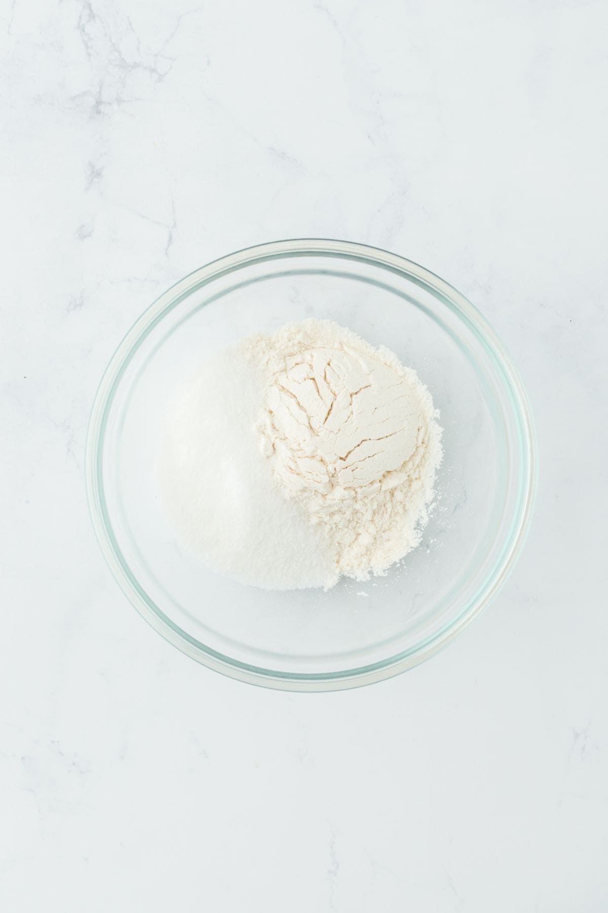 A glass bowl filled with a mixture of dry ingredients