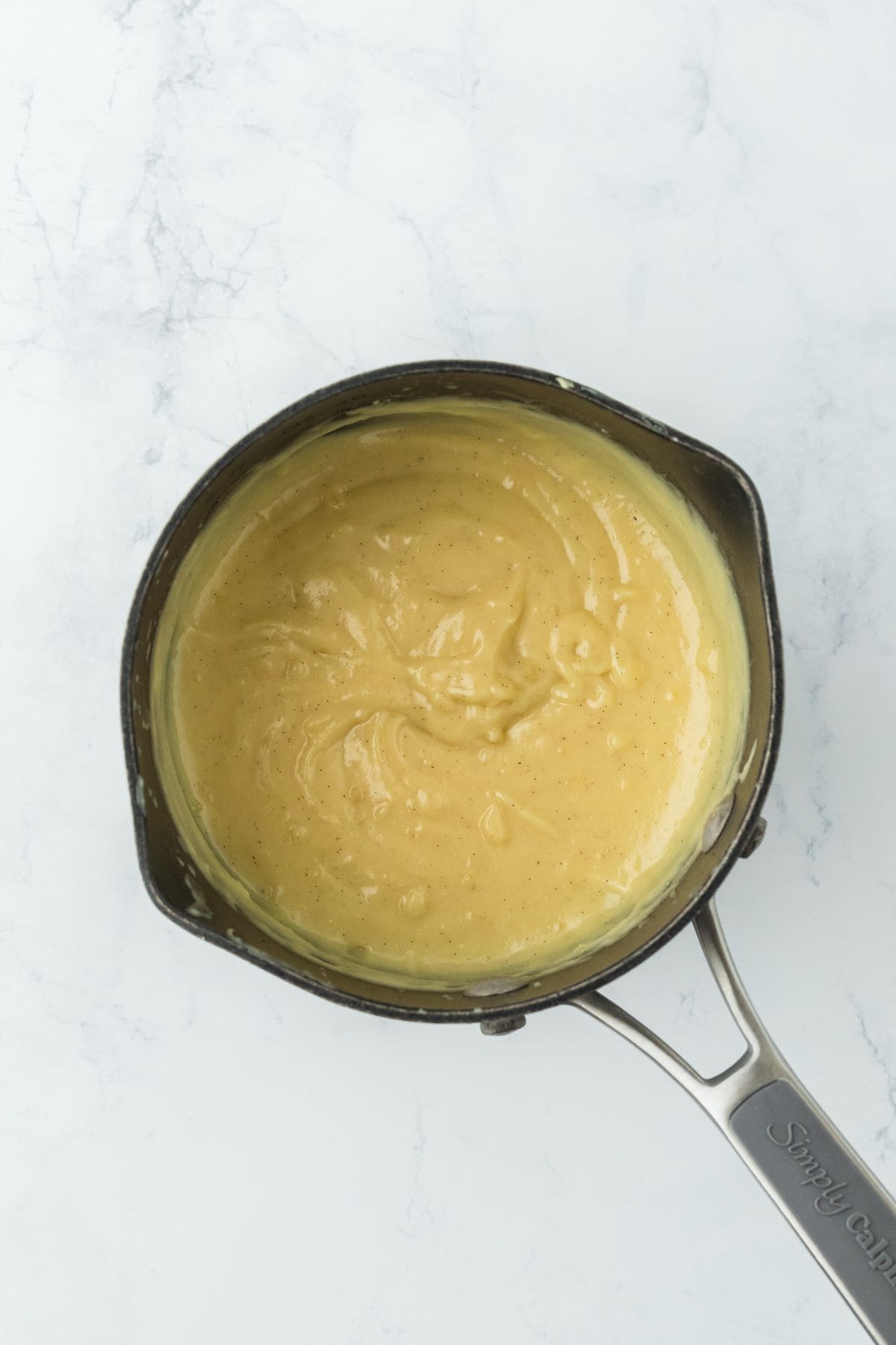 A saucepan containing thickened custard