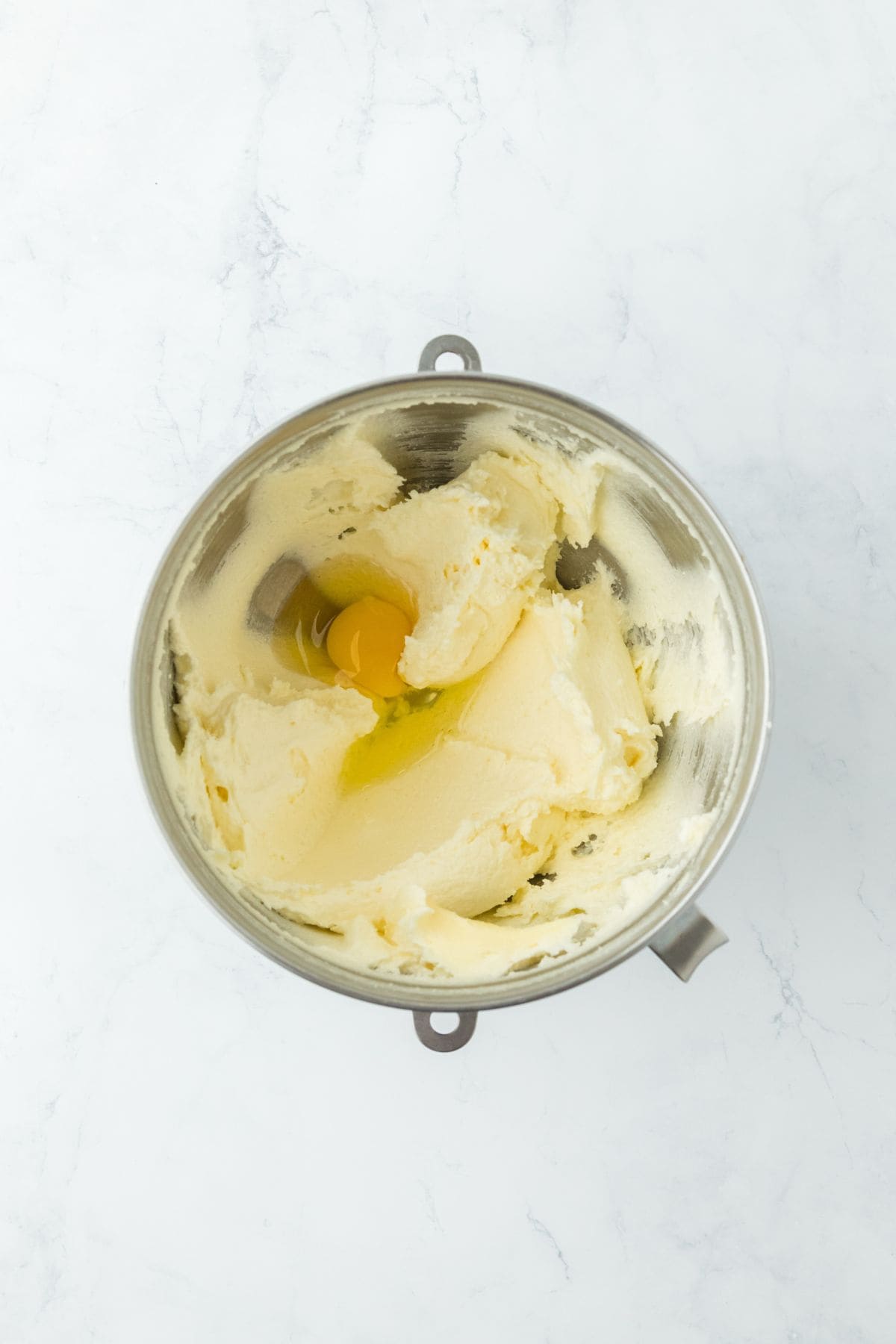 Creamed butter and sugar mixture with an egg cracked into the center