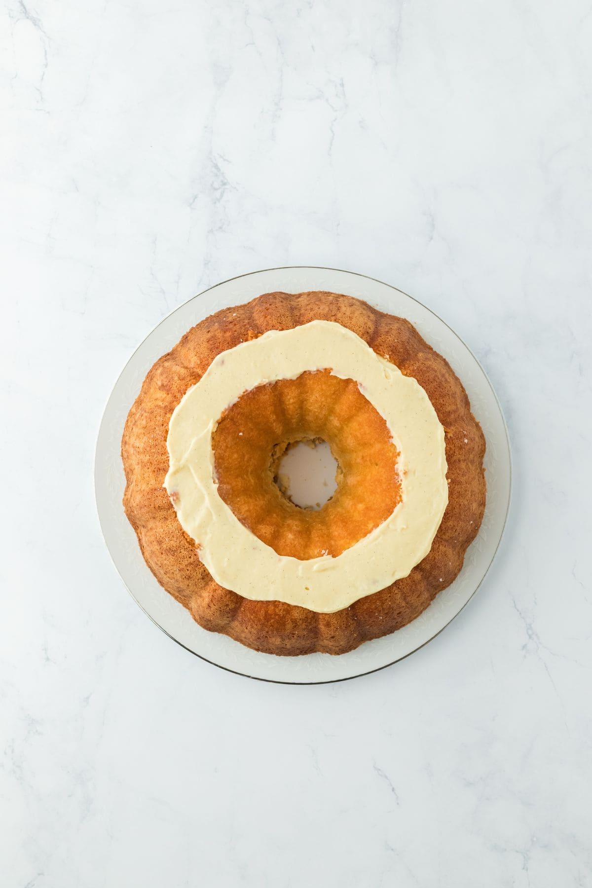 A layer of creamy custard spread on the carved surface of the pound cake