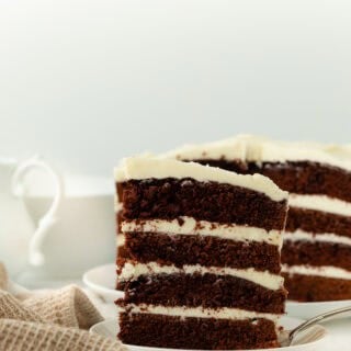 Slice of Devils food cake on white plate in white background