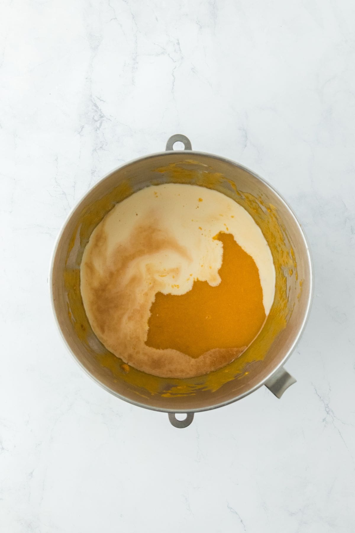 Evaporated milk and vanilla extract poured into the sweet potato pie mixture