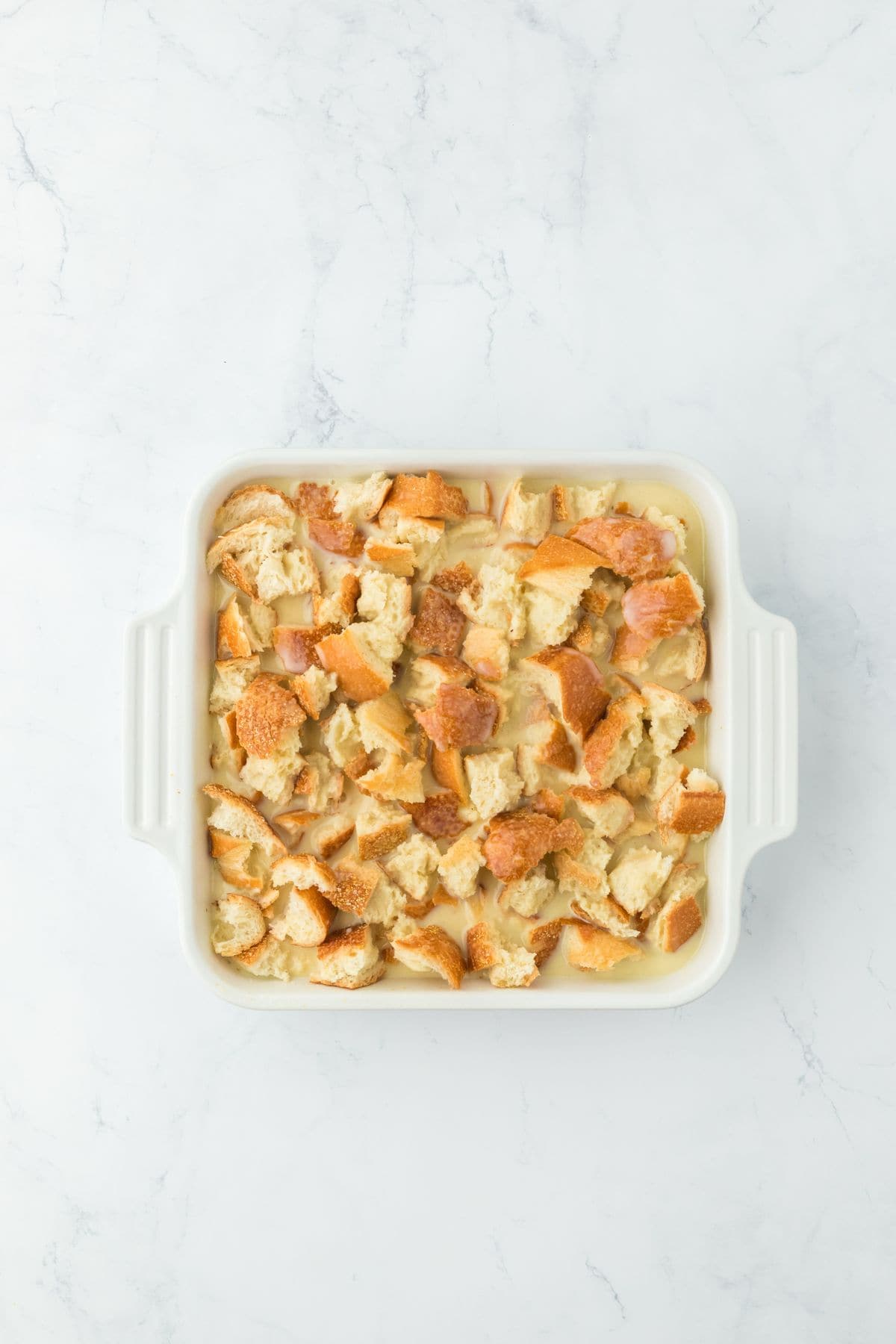 Bread pieces soaked in custard mixture in a baking dish