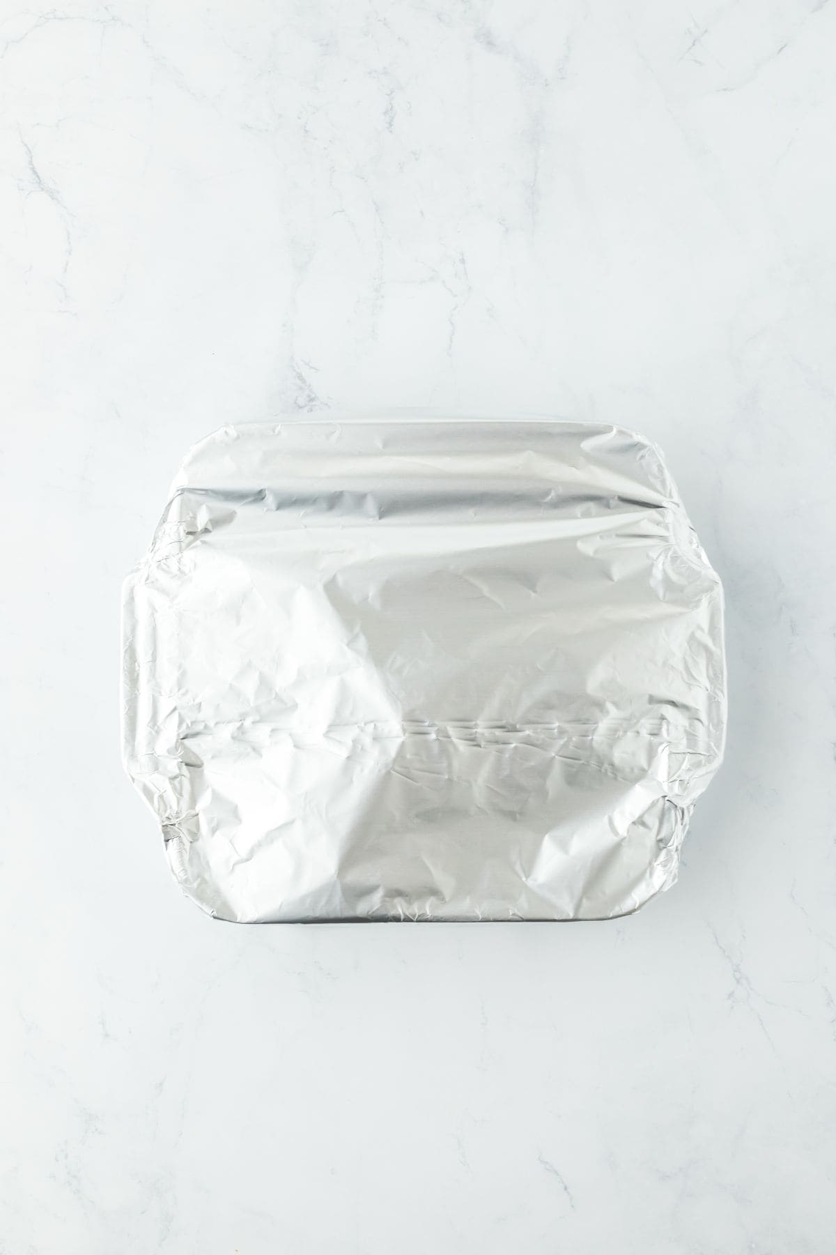 Baking dish covered with aluminum foil, ready for the oven