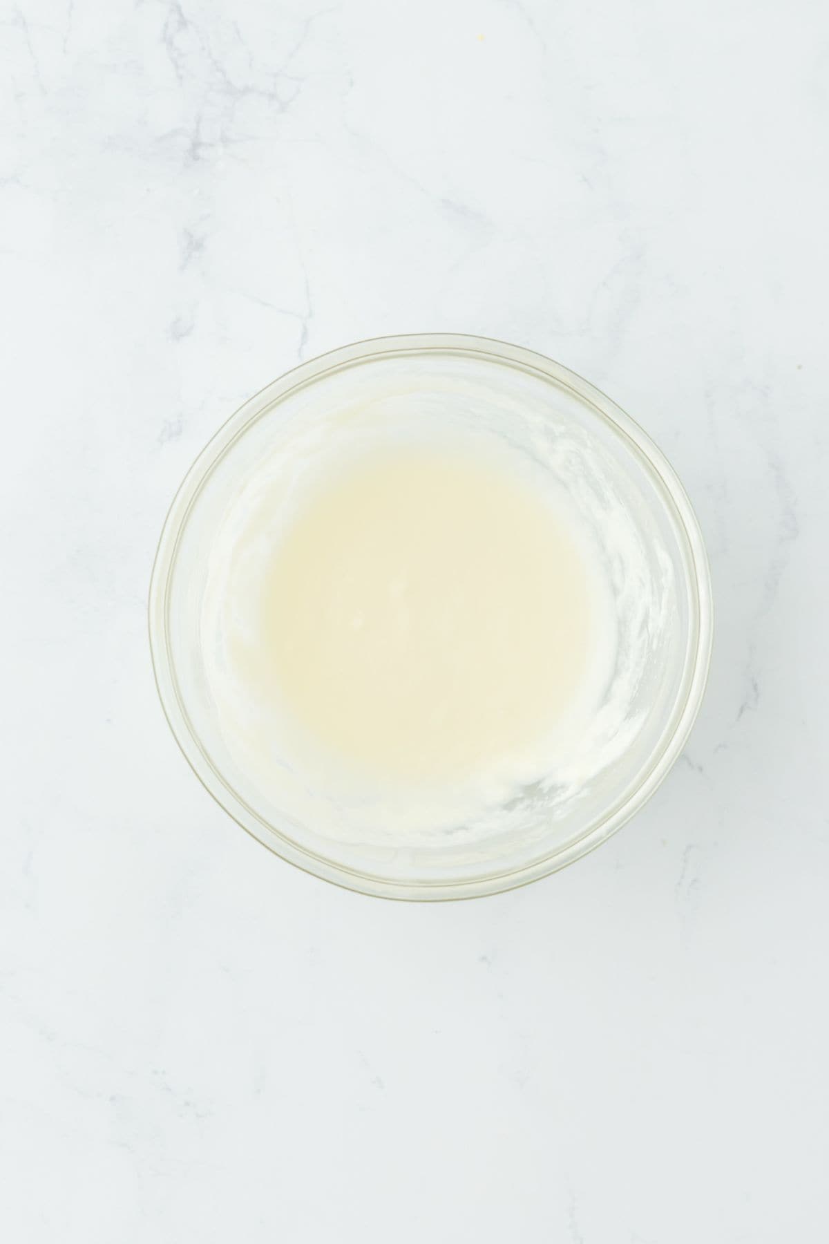 A smooth and creamy glaze mixture in a glass bowl