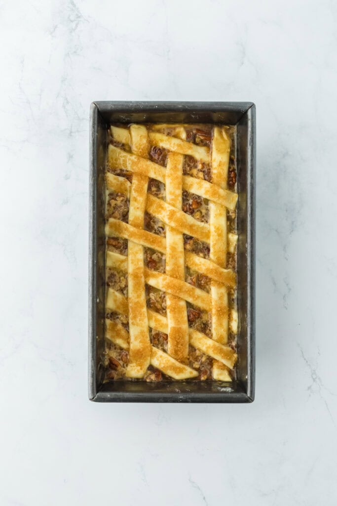 Lattice puff pastry added to pecan cobbler recipe with sugar on top before baking.