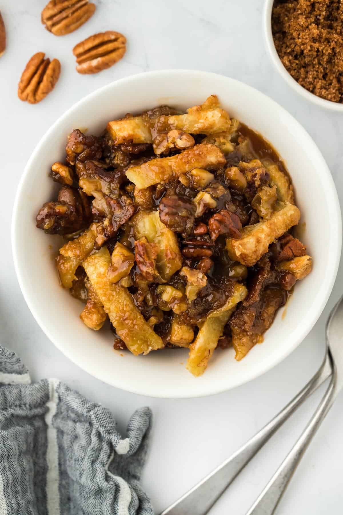 Pecan pie cobbler recipe in a white bowl ready to serve on white countertop