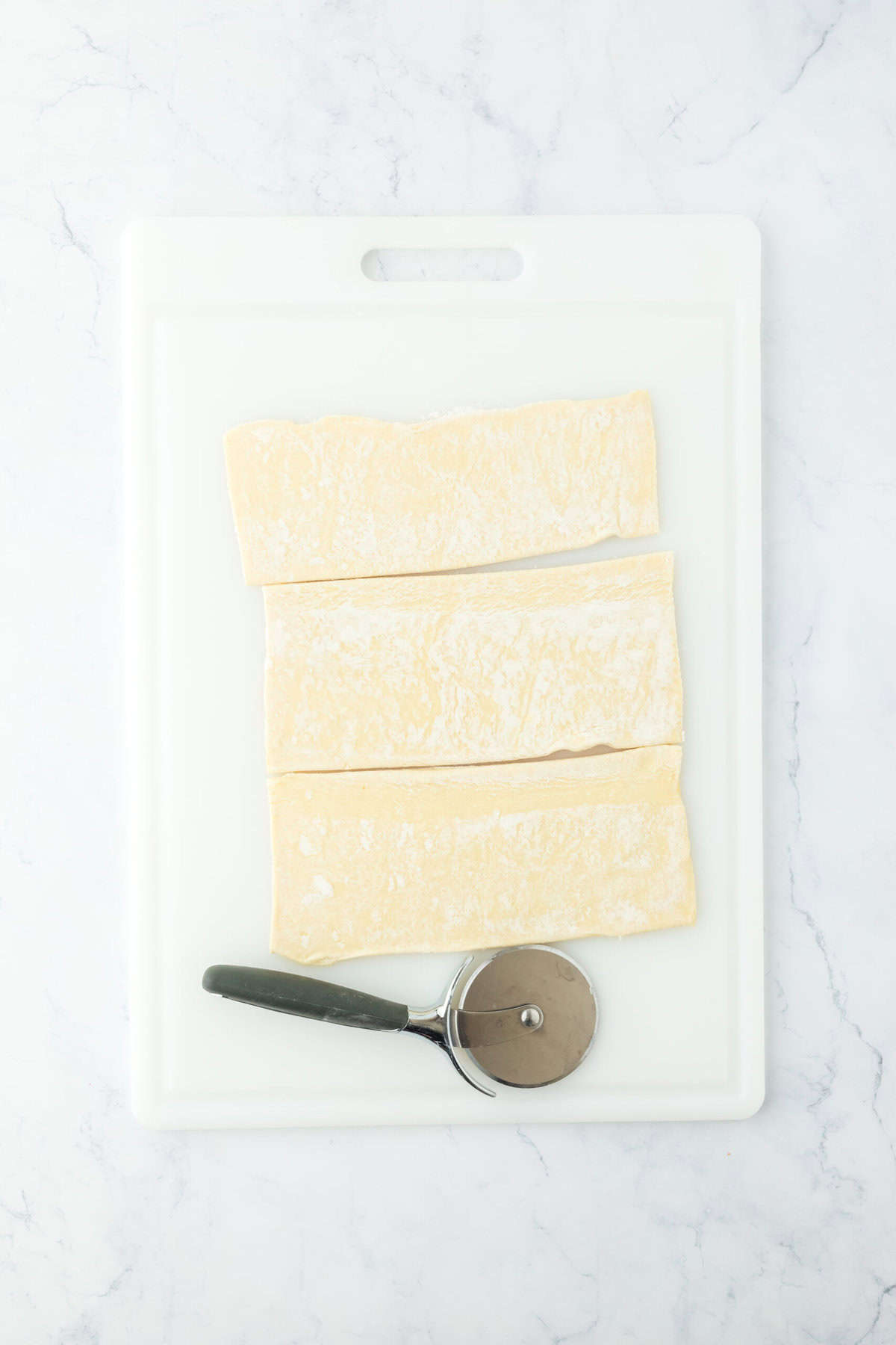 Cut puff pastry sheet on a cutting board into 3 strips