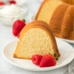 A slice of the best pound cake recipe on a white plate with berries to serve