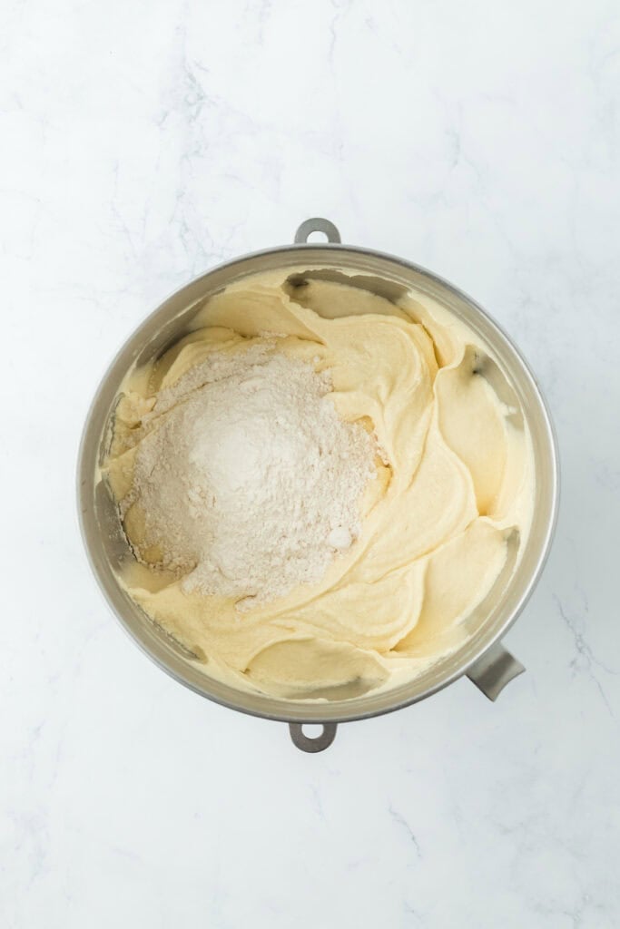 More flour being added to finish a Southern pound cake batter in stand mixer bowl