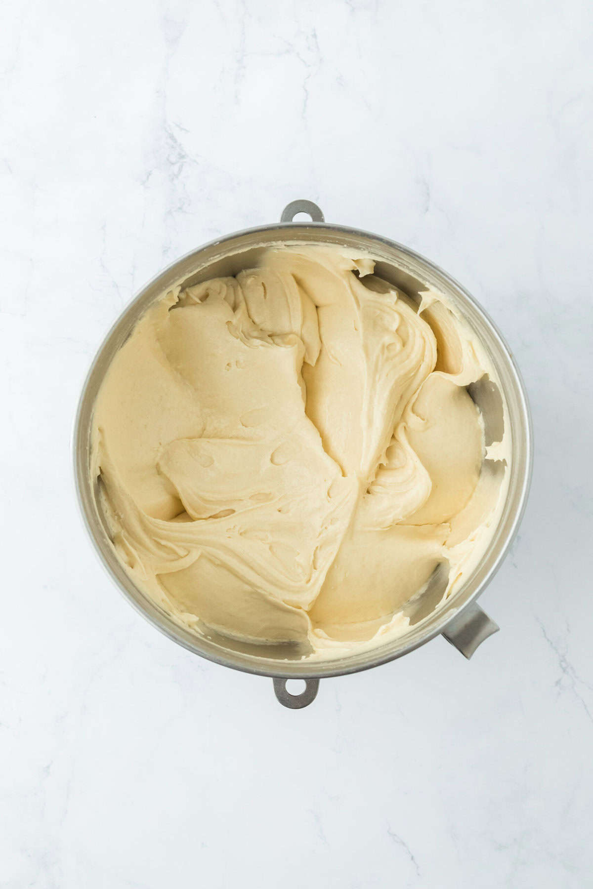 Finished easy pound cake batter in a stand mixer bowl on white countertop