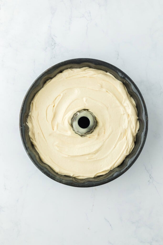 Delish pound cake batter in a greased bundt pan before baking