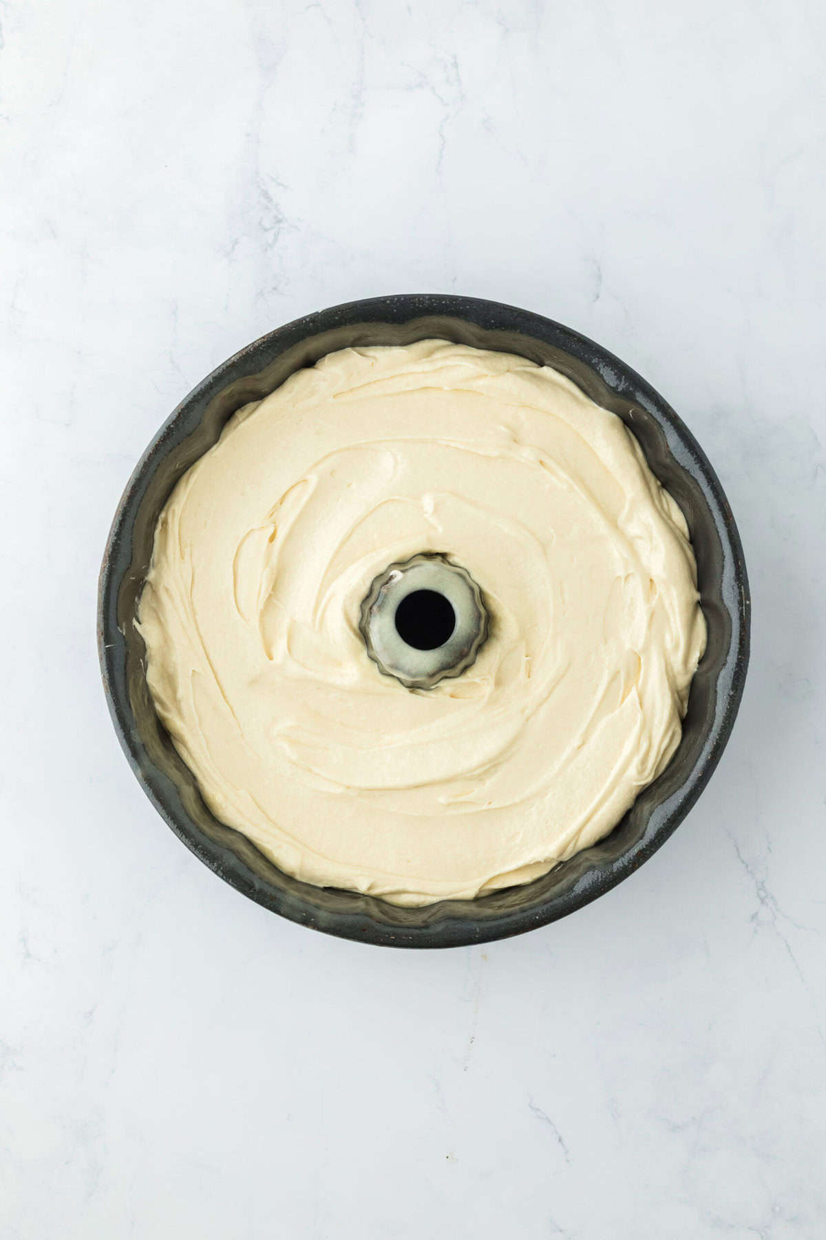 Delish pound cake batter in a greased bundt pan before baking