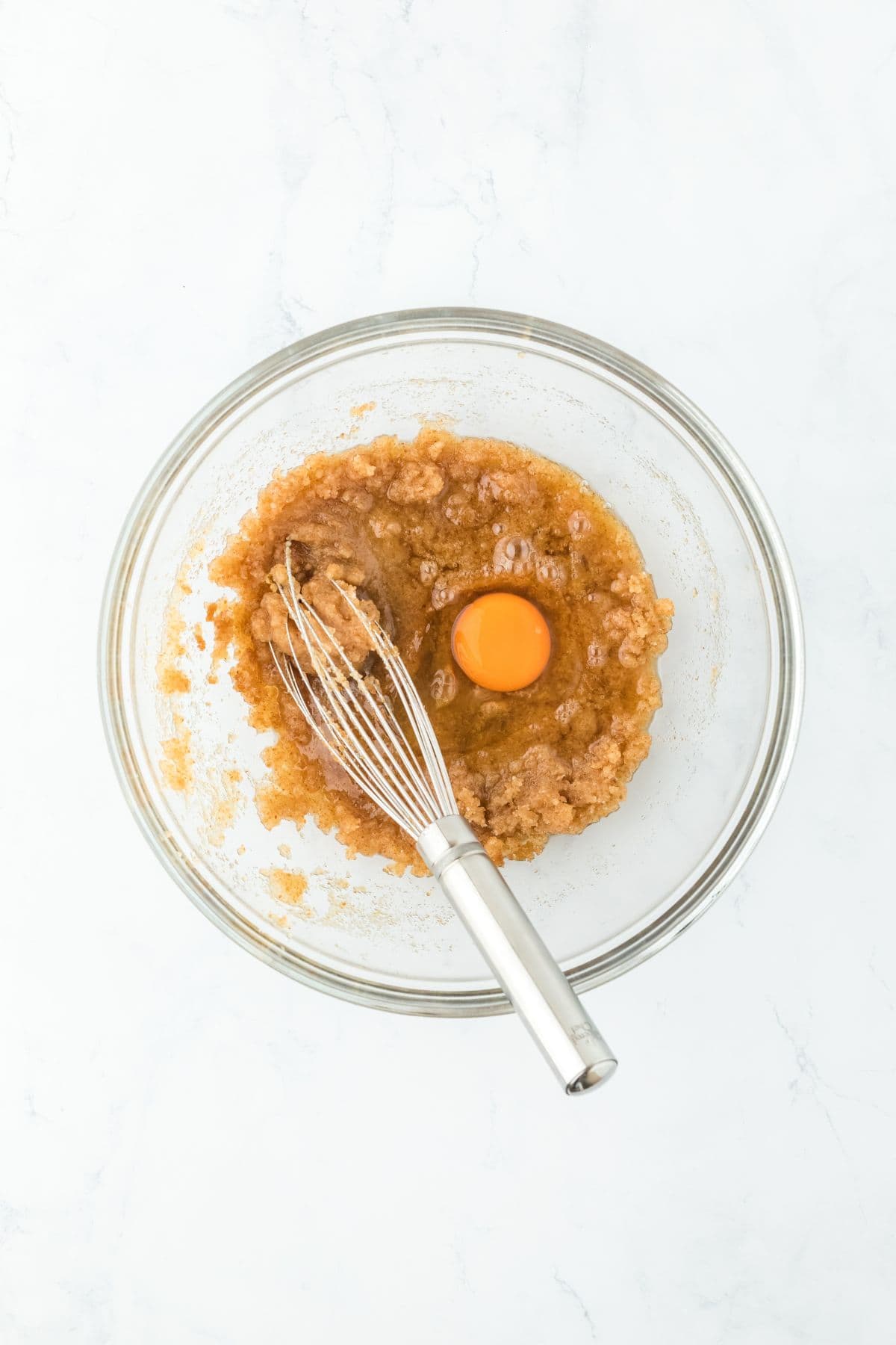 Whisk mixing ingredients in a bowl with an egg added