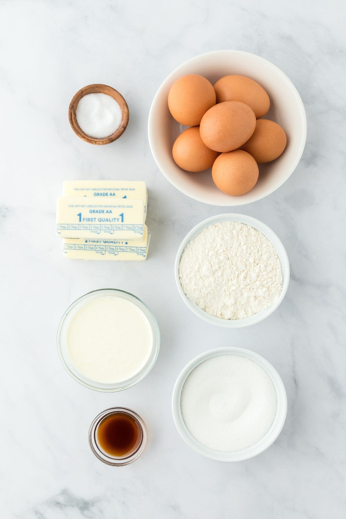 Overhead shot of ingredients to make whipping cream pound cake on a white surface before mixing