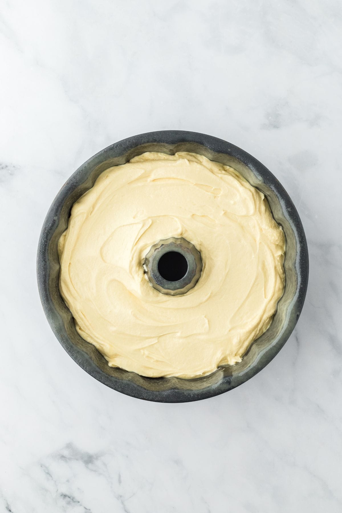 A bundt pan filled with cake batter, ready to bake