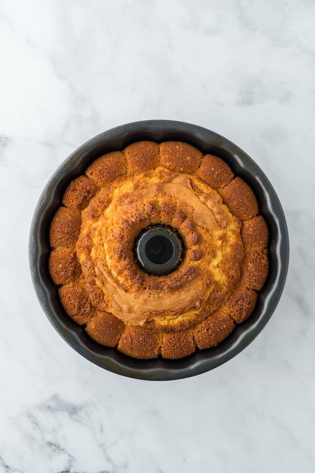 A golden-brown pound cake freshly baked in the bundt pan