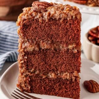 A slice of Gernan chocolate cake on a white plate with silver fork