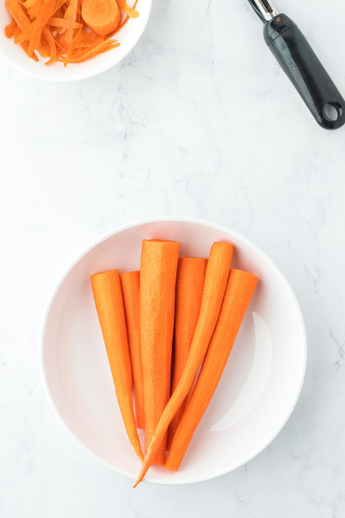 Whole carrots in a white bowl