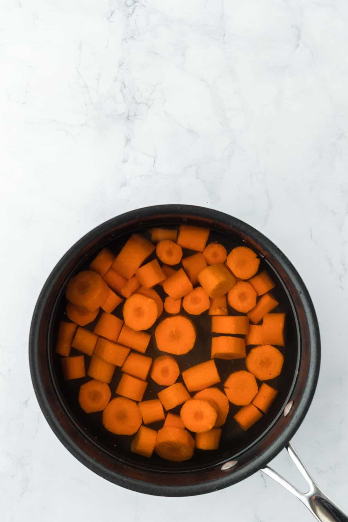 Carrot slices boiling in a pot of water