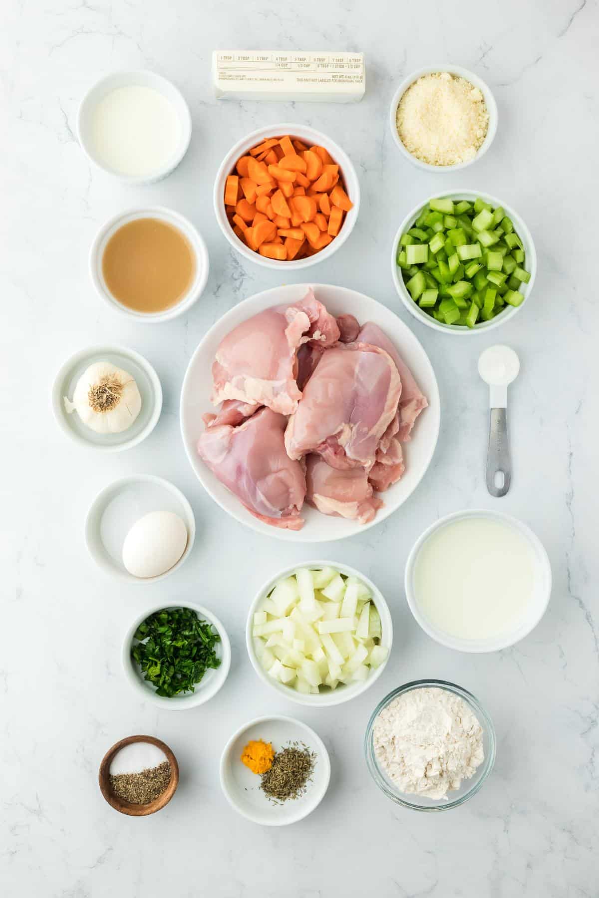 Overhead shot of ingredients for making chicken and dumpling soup on a marble surface before cooking