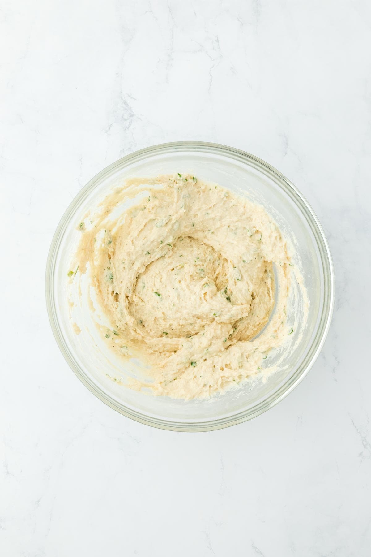 Mixed dumpling batter in a glass bowl, ready to be used