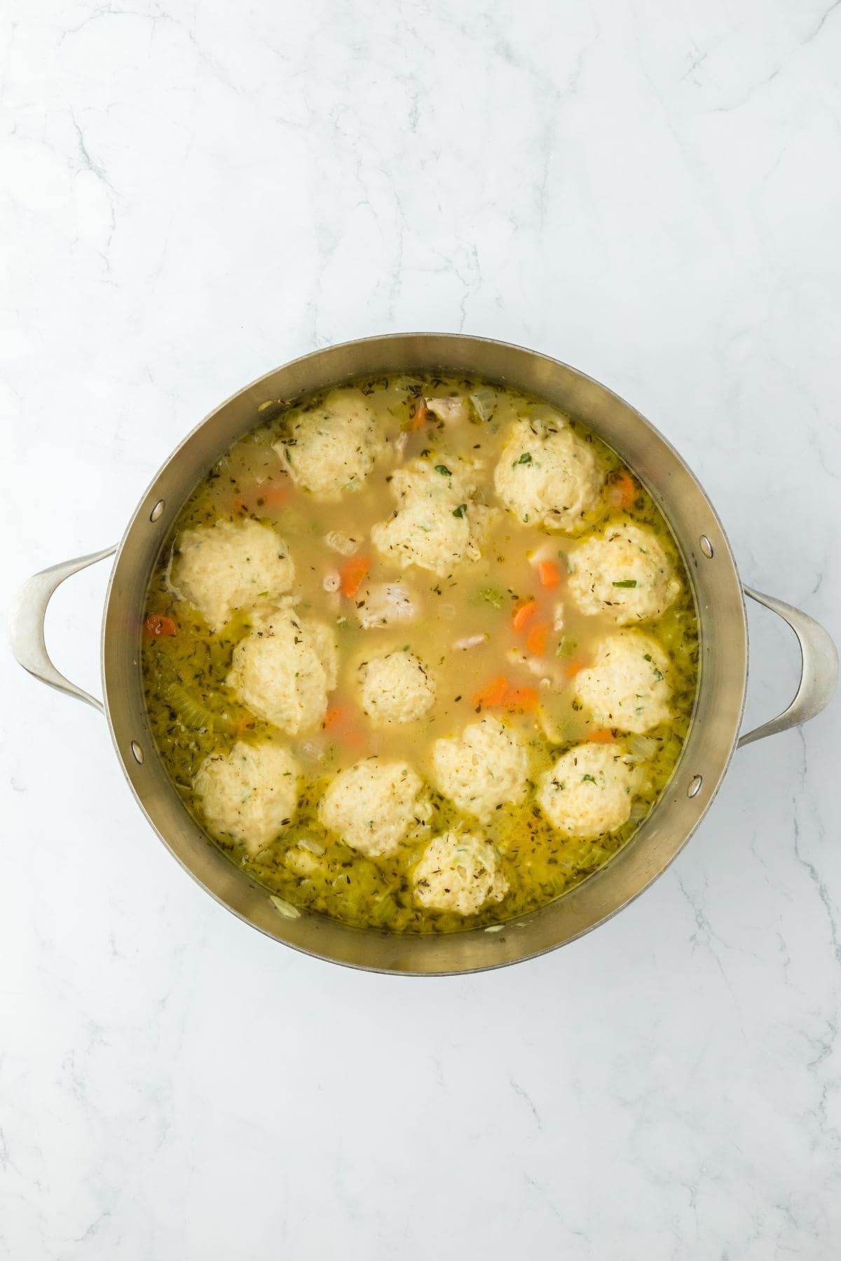 Fully cooked dumplings in the pot of soup, thickened and ready to serve