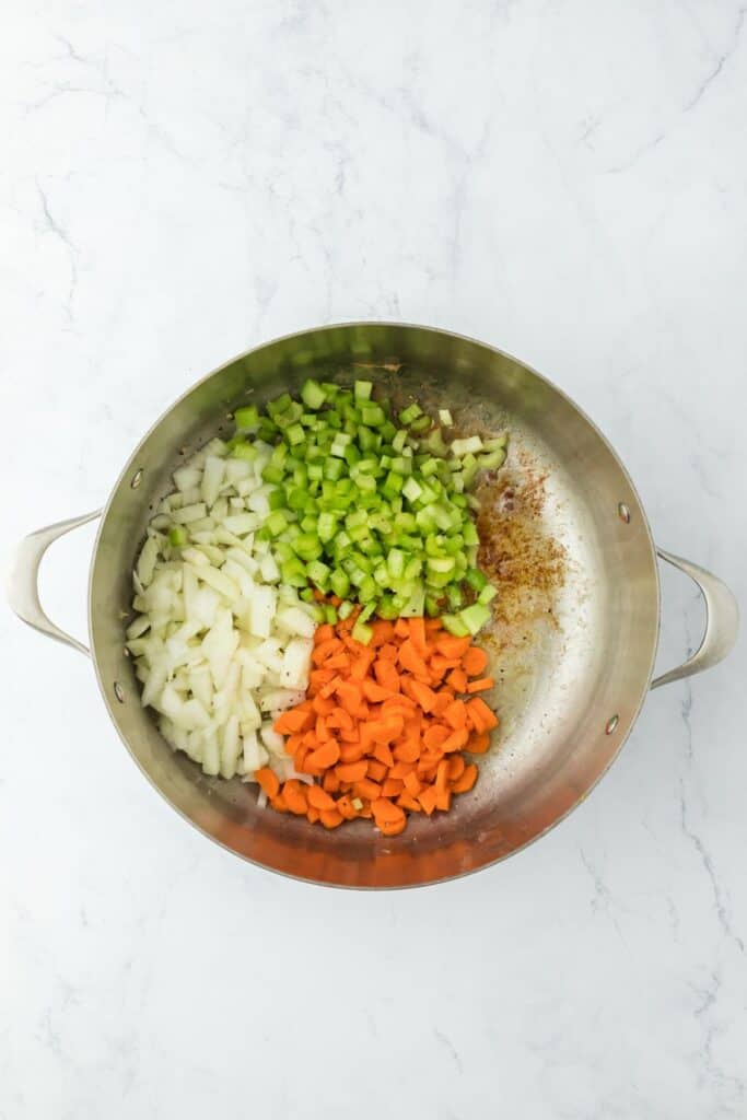 Chopped onions, carrots, and celery added to the pot with the cooked chicken