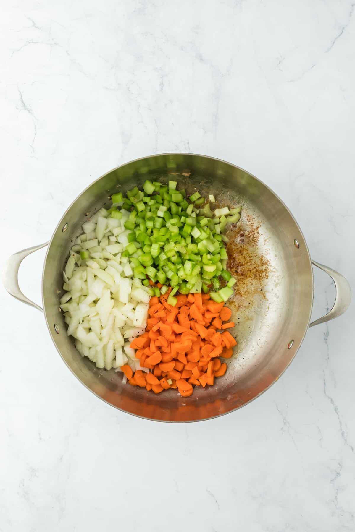 Chopped onions, carrots, and celery added to the pot with the cooked chicken