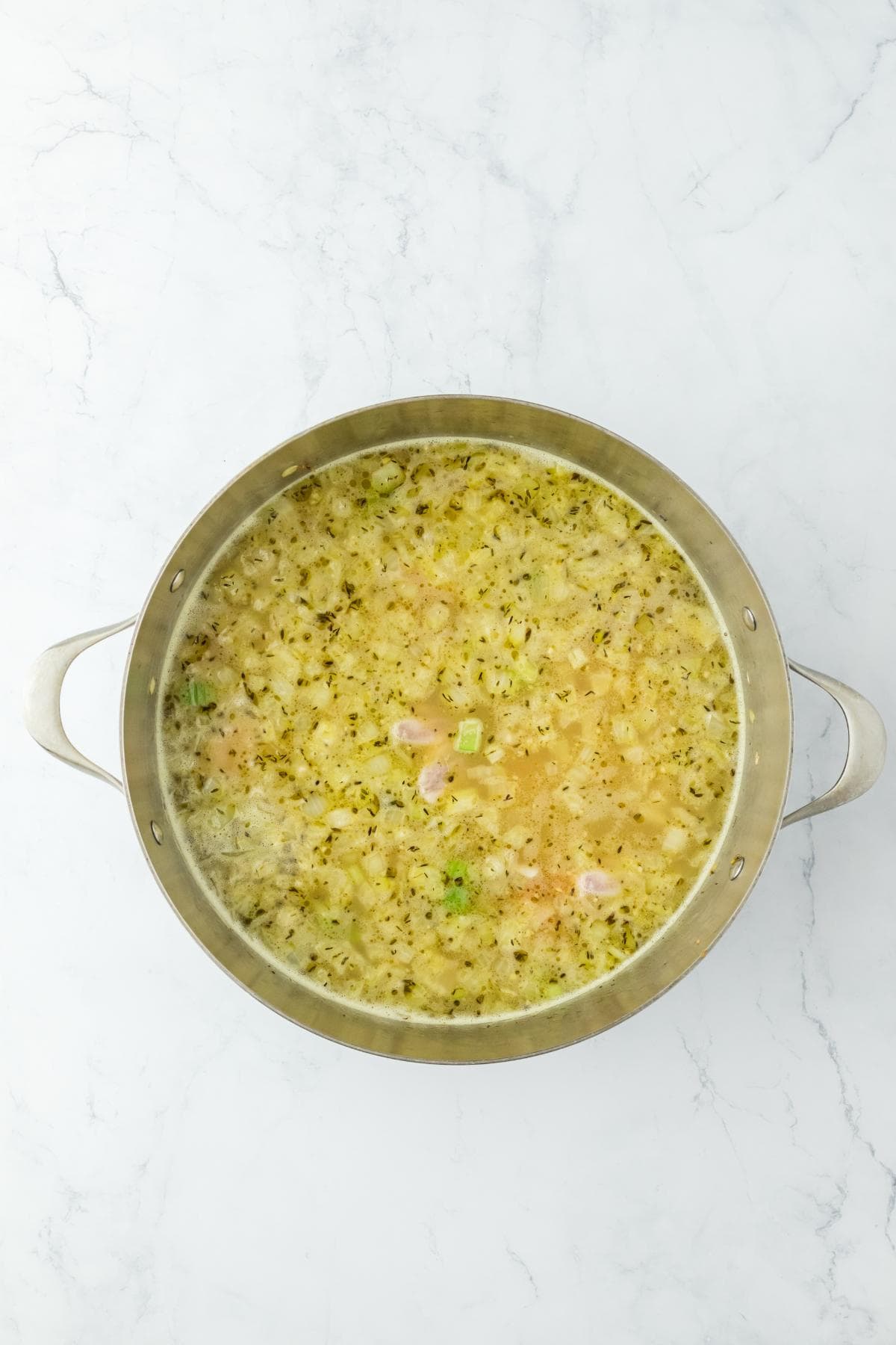 A pot of broth with added ingredients, thickening slightly