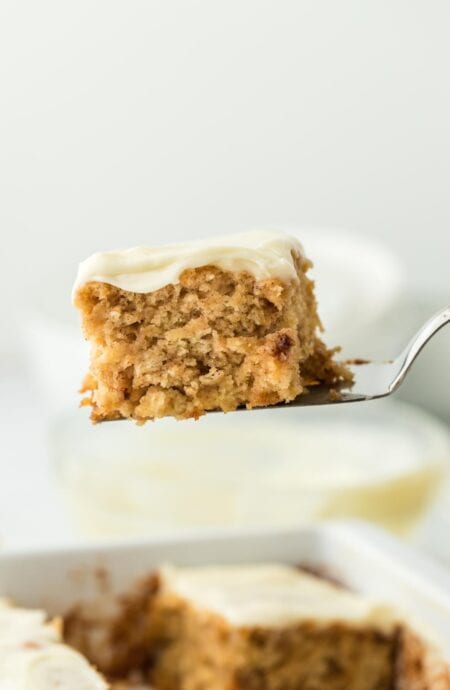 A single serving of cinnamon roll butter swim biscuits being lifted with a spatula from the baking dish