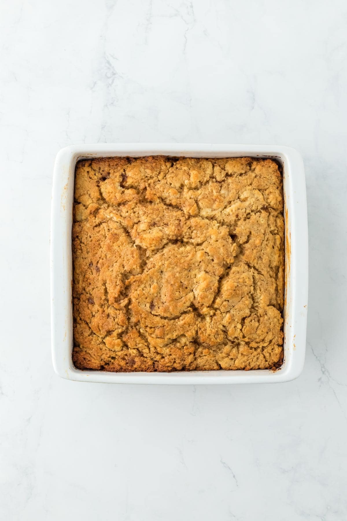 Fully baked cinnamon roll butter swim biscuits with a golden-brown crust in a baking dish