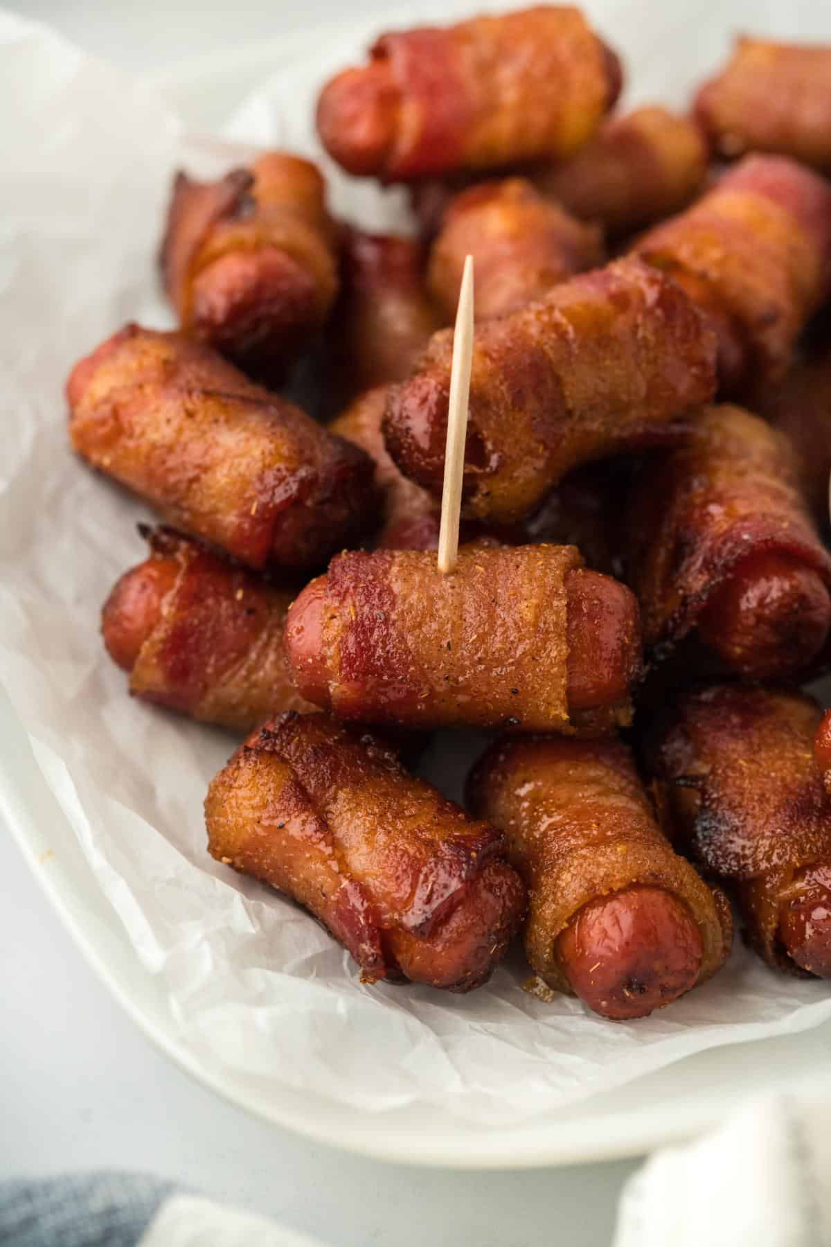 A closeup of the bacon wrapped smokies with a toothpick stuck in one of them